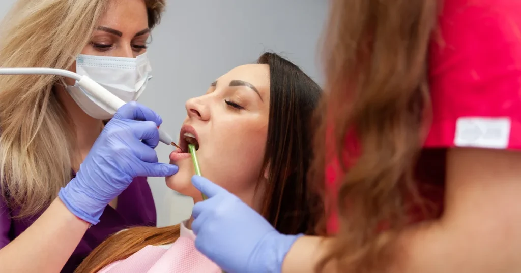 En kvinde får undersøgt sine tænder hos en tandlæge efter at have oplevet en knækket tand.