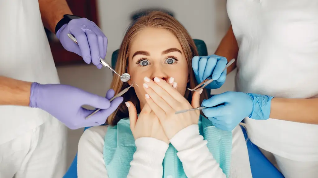 En kvinde med åben mund er til undersøgelse hos en tandlæge for Tandlægeskræk.