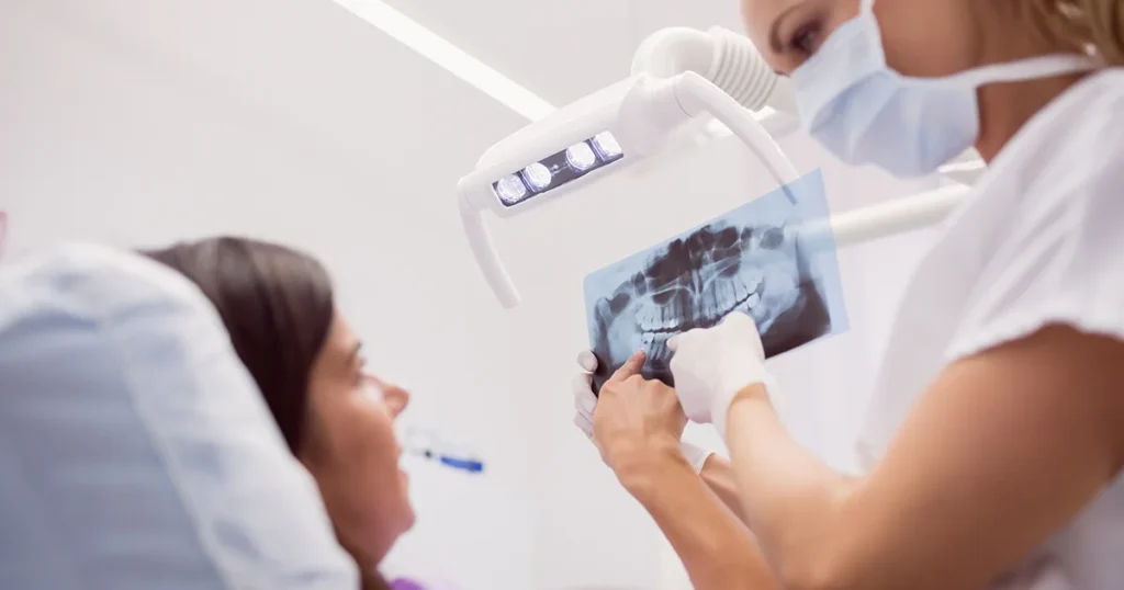 En kvinde får et tandrøntgenbillede af en tandlæge.