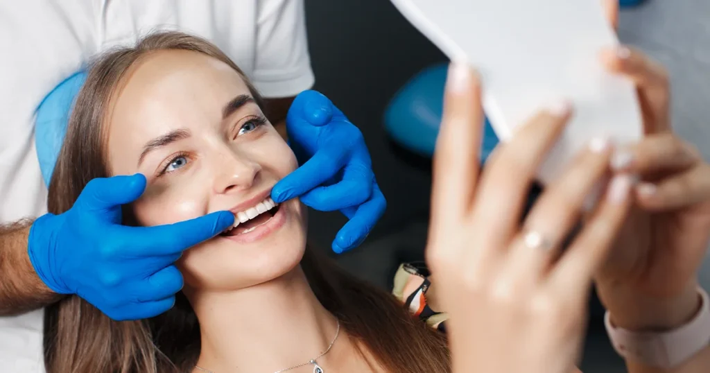 En kvinde får renset sine tænder hos en tandlæge ved hjælp af tandregulering (ortodontisk behandling).