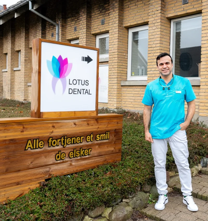 En mand, der står foran et Lotus Dental-skilt.