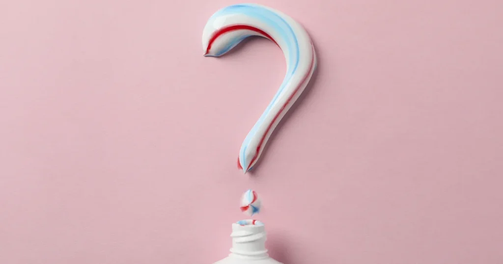 En flaske tandpasta med et spørgsmålstegn på, der fremmer tandsundheden og de væsentlige fordele ved fluor.